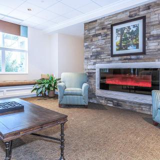 A cozy living room with a fireplace, armchair, and coffee table.