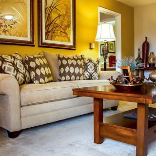 A cozy living room with a beige sofa, patterned cushions, and wooden coffee table.