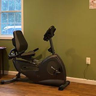 A recumbent exercise bike in a home gym setting.