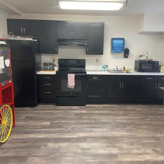 Modern kitchen with black cabinetry and a popcorn machine.