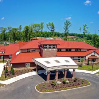 Aerial view of a building with a red roof surrounded by trees.
