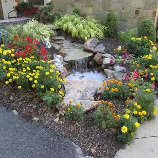 A beautifully landscaped garden with colorful flowers and a small water feature.