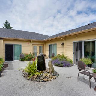 A cozy courtyard with a central fountain surrounded by plants and outdoor seating.