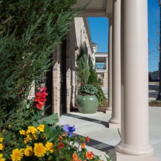 A sunny day with colorful flowers and architectural columns in view.