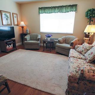 A cozy living room with a sofa, armchairs, and a television.