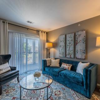 A cozy living room with a stylish blue sofa, modern armchair, and elegant decor.