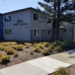 A view of the exterior of an apartment building with landscaped grounds.