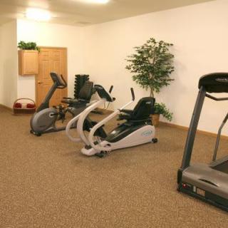 A small indoor gym with various exercise equipment, including a treadmill and stationary bike.