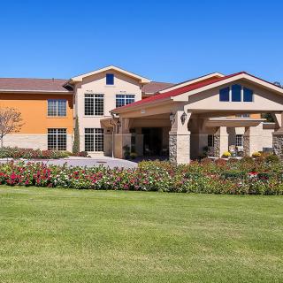 A beautiful residential building with a well-manicured lawn and vibrant landscaping.