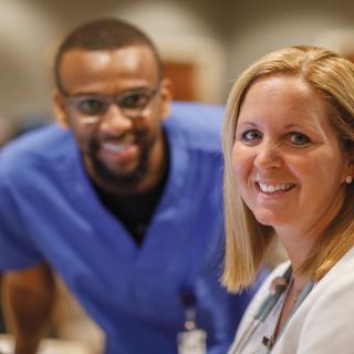 Two healthcare professionals are smiling and working together.
