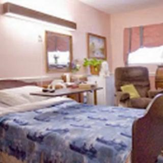 A hospital room with a bed, chairs, and decorative elements.