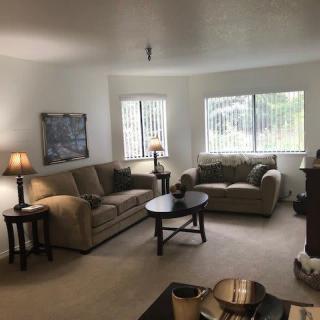 A cozy living room with sofas, tables, and lamps.