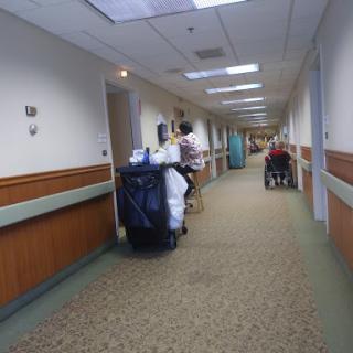 A corridor in a hospital featuring healthcare staff and patients.