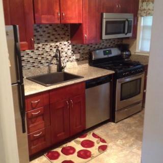 A modern kitchen with stainless steel appliances and wooden cabinetry.