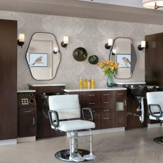 Modern barber shop interior with stylish chairs and mirrors.
