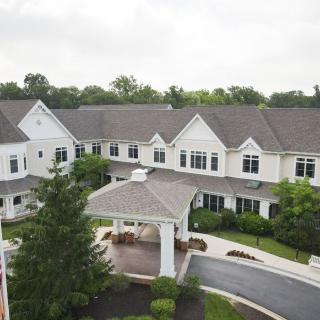 A large residential building with an entrance and landscaped surroundings.