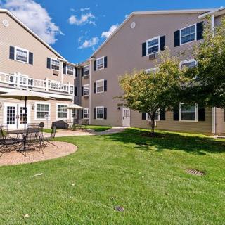 A view of a residential apartment complex with well-maintained lawns and trees.