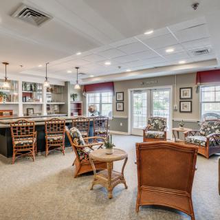 A spacious living area with a bar, comfortable seating, and large windows letting in natural light.