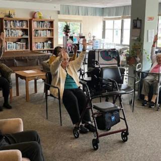 Elderly individuals participating in a seated exercise session at a community center.