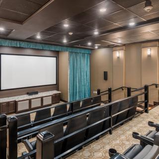 A luxurious home theater setup with tiered seating and a large screen.