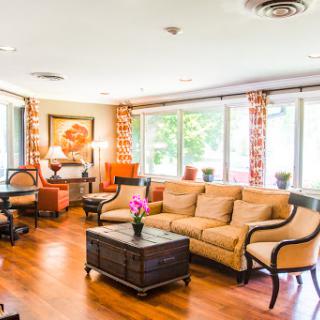 A cozy and well-lit living room featuring elegant furniture and a warm color palette.