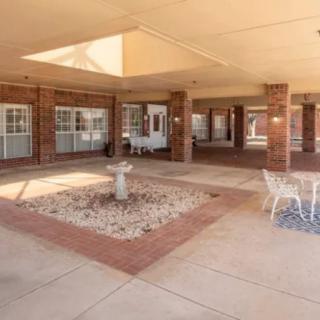 A spacious courtyard with a central fountain and brick surrounding, featuring multiple windows.