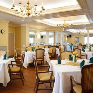 An elegant dining room with neatly arranged tables and chandeliers.