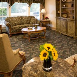 Cozy living room with a sofa, armchairs, and a coffee table decorated with sunflowers.