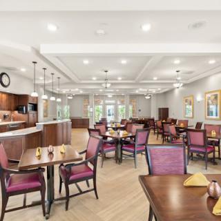 A spacious and modern dining area with elegant tables and chairs, featuring warm lighting and a welcoming atmosphere.