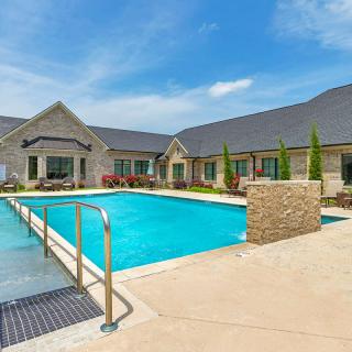 A modern residential building with a large outdoor swimming pool.