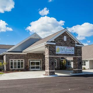 A modern building with a prominent entrance under a clear blue sky.