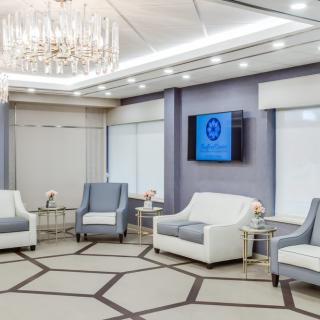 A luxurious and elegantly designed lounge area with modern furniture and a chandelier.