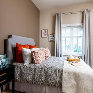 A cozy bedroom with decorative pillows and neutral tones.