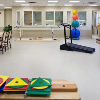 A rehabilitation center equipped with a treadmill, exercise balls, and various therapy tools.
