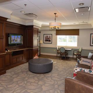 A cozy living room with modern furniture and a television mounted on the wall.