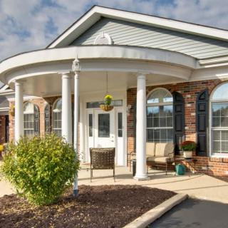 The front entrance of a building features classic columns and a covered porch.