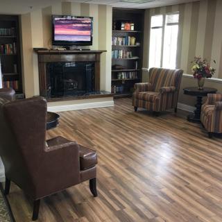 A cozy living room with a modern design featuring wood flooring, a fireplace, and comfortable seating.