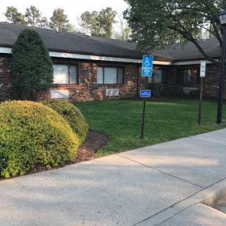 A well-maintained building surrounded by greenery and a clean pathway.