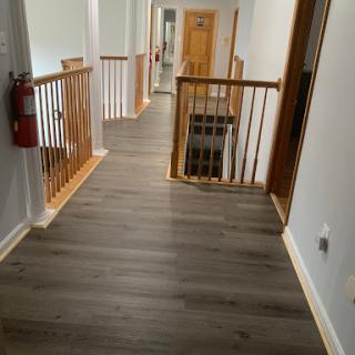 A well-lit hallway featuring wooden railings and modern flooring.