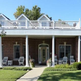 A traditional house with a spacious porch and outdoor seating.