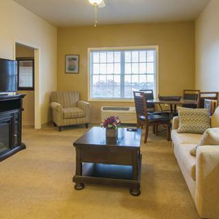 A cozy living room with a sofa, armchairs, and a coffee table arranged around a television.