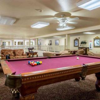 A spacious recreational room featuring a pool table and comfortable seating.