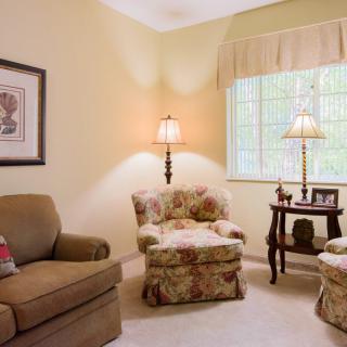 Cozy living room with armchairs, a sofa, and soft lighting.