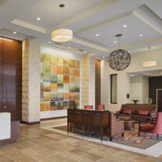 A hotel lobby with modern design, featuring a reception desk and seating area.