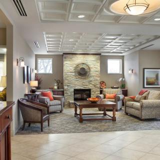 A cozy and elegantly designed living room featuring comfortable seating, a central coffee table, and a fireplace.