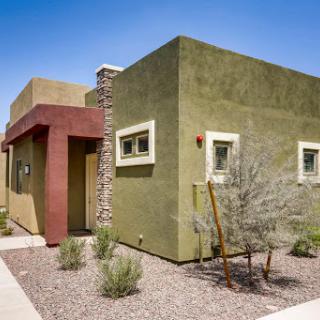 A modern house featuring a unique design and desert landscaping.