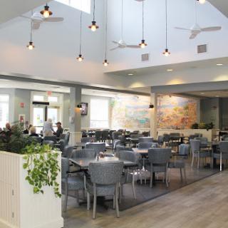 A spacious and modern restaurant interior featuring stylish furnishings and ambient lighting.