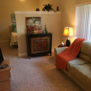 A cozy living room with a sofa, lamp, and television.