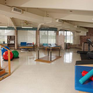 A spacious and well-equipped therapy room designed for rehabilitation exercises.