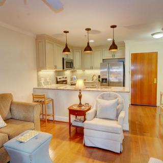 A cozy open-plan living room and kitchen area with modern furnishings and warm lighting.